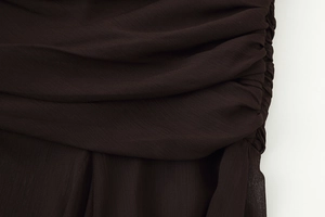 Detail of ruched design and textured chiffon fabric on a dark brown summer skirt