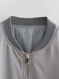 Front detail of gray bomber jacket showing ribbed collar and metallic silver zipper