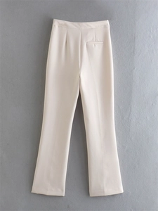 Detail view of high waist cream trousers showing the tailored back seam and clean pockets