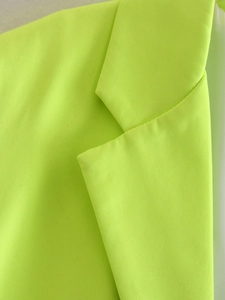 Macro shot of fluorescent green suit fabric with lapel detail and weaving texture
