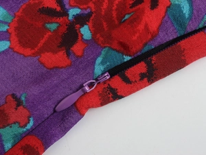 Détail de l'imprimé fleuri rose rouge sur tissu violet avec fermeture éclair invisible