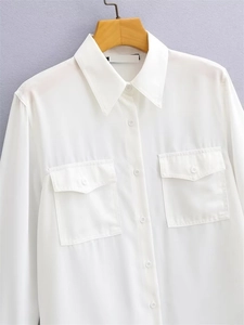 Women's casual white long sleeve blouse with dual breast pockets and a loose fit drape