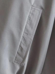 Detailed close-up of grey flight jacket pockets with premium stitching and texture