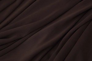 Close-up of lightweight dark brown chiffon fabric with pleated texture and sheer finish