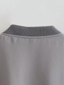 Close-up of dark grey ribbed knit collar and high-quality stitching on a bomber jacket