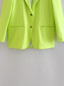 Detail view of fluorescent green casual blazer showing two-button closure and smooth fabric