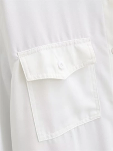 Detail of a white drape shirt featuring a front flap pocket with a matching button