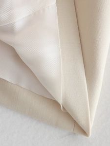 Macro detail of beige textured fabric with white smooth lining and precise stitching