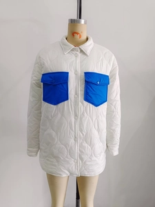 Detail of white quilted jacket with contrasting bright blue patch pockets and buttons