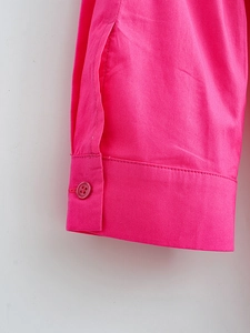 Close-up of bright rose pink poplin shirt cuff with matching button and neat stitching