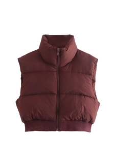 Close-up of deep burgundy puffer vest with high stand collar and ribbed hem details