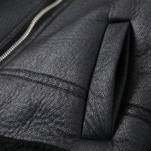 Nahaufnahme der schwarzen Kunstlederjacke mit Litschi-Textur und silbernem Reißverschluss