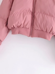Detailed view of quilted pink puffer jacket with resin zipper and ribbed hem texture