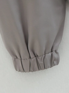 Detailed close-up of grey bomber jacket elastic cuffs with fine twill woven texture