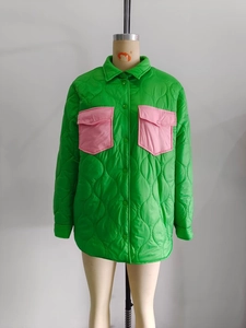 Close-up of bright green quilted jacket featuring contrasting pink front flap pockets