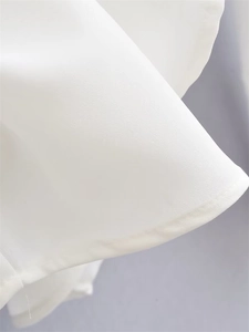 Close-up of white chiffon fabric texture and high-quality hem stitching on the sleeve