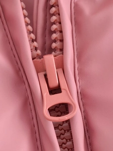 Macro detail of high-quality pink plastic zipper and reinforced stitching on jacket
