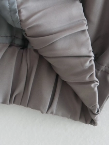 Detail of grey bomber jacket showing elastic ribbed cuff and premium twill fabric texture