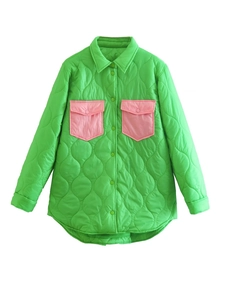 Detail of green quilted jacket featuring contrasting pink breast pockets and stitching