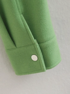 Women's grass green woolen jacket sleeve detail with minimalist silver metal button