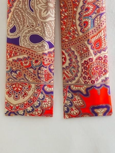 Détail d'un pantalon taille haute avec des imprimés Paisley ethniques et colorés