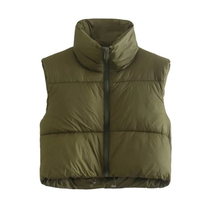 Detail of dark green puffer vest showing high collar and adjustable drawstring hem