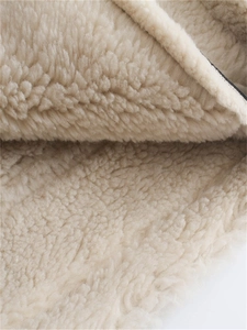 Detailed macro view showing the thick texture of cream fleece lining on winter jacket