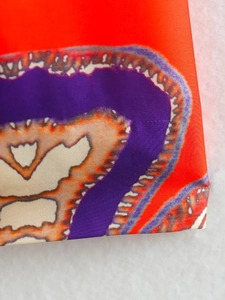 Gros plan sur tissu rouge imprimé bohème avec coutures précises et texture soyeuse