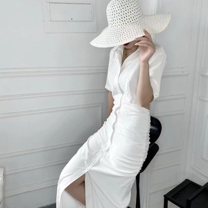 Detail of white button-down midi dress with waist pleats and side slit detail