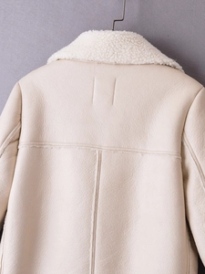 Detail des weichen Lammfellkragens und der cremefarbenen Ledertextur der Winterjacke