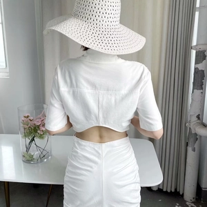 Detail of white short sleeve top with back cutout and matching ruched long skirt