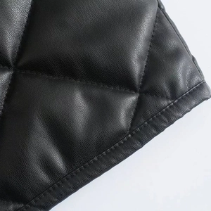 Close-up of black quilted PU leather with diamond stitching and fine texture details