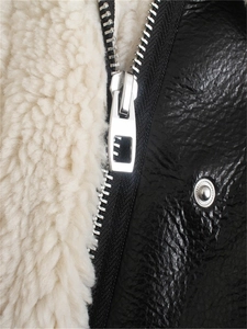 Detail of black faux leather jacket with cream fleece lining and silver zipper