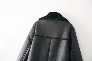 Nahaufnahme der schwarzen Lammfelljacke mit Fokus auf Rückennähte und Lederstruktur