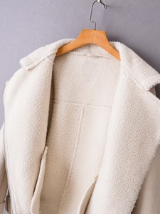 Nahaufnahme der beigen Lammfelljacke mit dickem Wollfutter und Metallreißverschluss