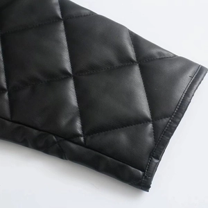 Close-up of black diamond-quilted faux leather jacket with detailed stitching