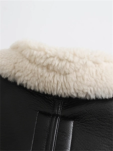 Close-up of black faux leather jacket collar with thick cream faux shearling lining