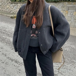 Detail of grey wool blend bomber jacket with metal button closure and slanted side pockets