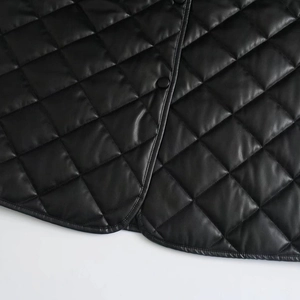 Close-up of diamond quilted black PU leather jacket with matte button and edge stitching
