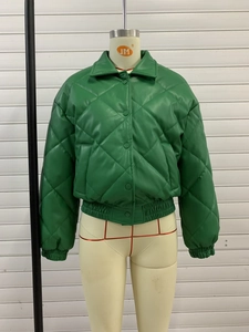 Detail of green quilted PU leather jacket with diamond pattern and button closure