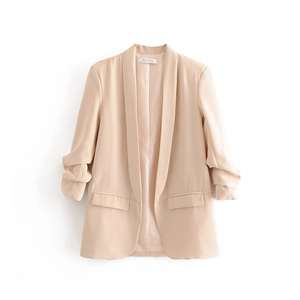Close-up of shawl collar and pleated sleeve cuffs on apricot casual blazer