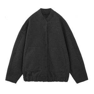 Close-up of black sherpa jacket texture featuring large front utility pockets and ribbed hem