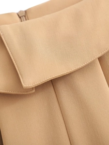 Makro-Detail des khakifarbenen Faltenrocks mit Twill-Stoff und Taschenklappendesign