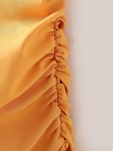 Detailed view of yellow dress side seam featuring dense vertical pleated gathering detail