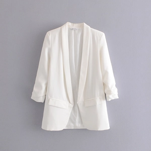 Detailed view of white blazer featuring stylish pleated cuffs and shawl collar design