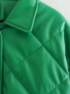Close-up of green quilted faux leather jacket showing diamond pattern and fine stitching