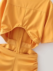 Detail of bright yellow dress showing cutout waist design and elastic shirring textures