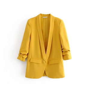 Detail of yellow blazer with ruched sleeves, shawl lapel and decorative flap pockets