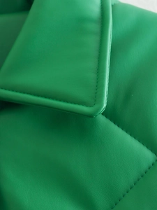 Detailed macro view of quilted emerald green faux leather jacket with neat lapel stitching