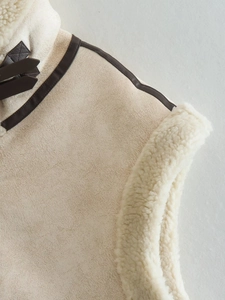 Close-up of beige faux suede vest with cream fleece lining and dark brown buckled collar detail